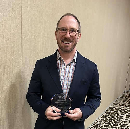 Rob Carlson holding Volunteer of the Year Award