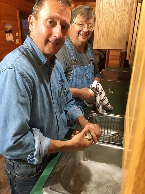Bill Sullivan and Doug Nelson washing dishes and smiling